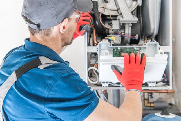HVAC technician peforming a service on a residential gas furnace