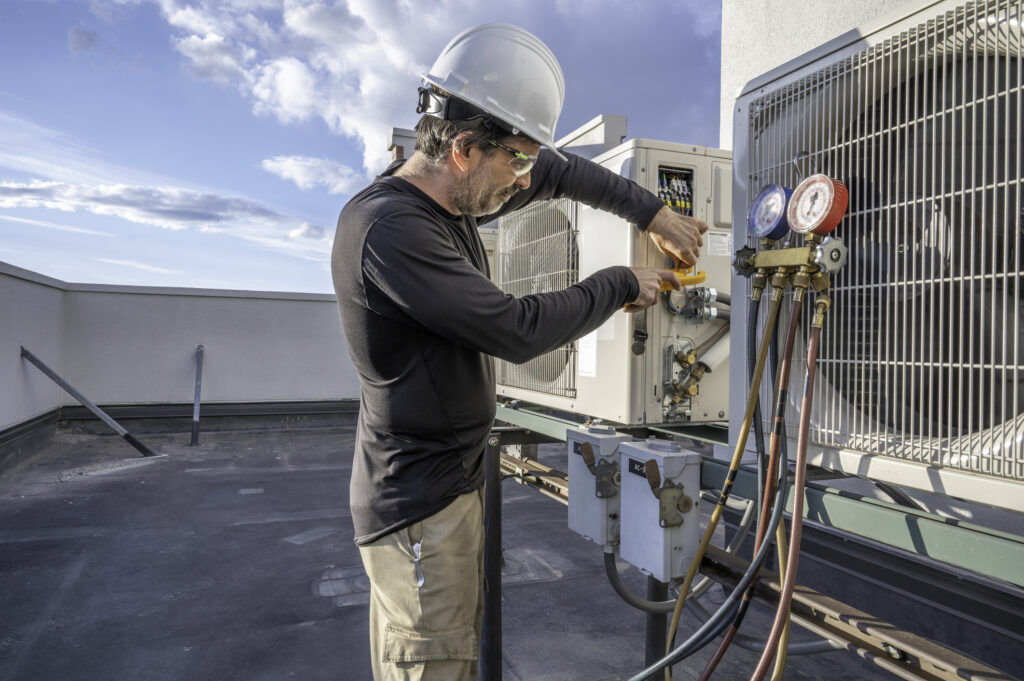 HVAC tehcnician working on a commercial cooling unit